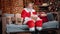 Adorable male Santa Claus with Christmas gift box posing at garland home. Wide shot on RED camera