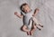 Adorable newborn baby with pacifier and toy sleeping on bed, top view