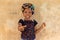Adorable Nigerian kid with colorful headband smiling and pointing at the camera