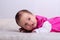 Adorable one month old baby girl in pink dress lies on a soft blanket