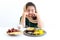 Adorable Pakistani Muslim girl with beautiful eyes sitting at kitchen table, kid wearing hijab and traditional costume feeling