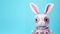 Adorable pink robotic bunny with big eyes on vibrant blue background