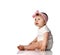 Adorable positive little baby girl in white cotton body, hair bow decoration and barefoot sitting on floor, smiling and looking up