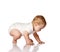 Adorable positive little baby infant in white cotton body and barefoot touching floor with hands and trying to stand up