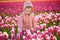 Adorable preschooler girl in beautiful blossoming tulip field
