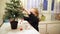 Adorable preschooler girl decorating little Christmas tree with miniature toys at home