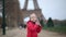 Adorable preschooler girl with a doll in front of the Eiffel tower in Paris, France