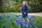 Adorable preschooler girl enjoying nice spring day in park during hyacinth blooming season