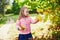 Adorable preschooler girl enjoying nice and sunny autumn day outdoors