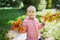 Adorable preschooler girl enjoying nice and sunny autumn day outdoors