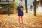 Adorable preschooler girl enjoying nice and sunny autumn day outdoors