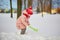 Adorable preschooler girl having fun in beautiful winter park on a snowy cold winter day