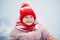 Adorable preschooler girl having fun in beautiful winter park on a snowy cold winter day