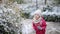 Adorable preschooler girl having fun in beautiful winter park on a snowy cold winter day