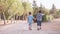 Adorable preschoolers, brothers, holding hands and walking in the park. Back view slow motion