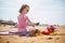 Adorable preshooler girl playing on the sand beach at Atlantic coast of Brittany, France