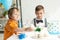 Adorable preteen boys sitting at table with cupcakes during birthday party.