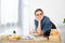 adorable preteen child resting chin on hand at table with books