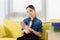 adorable preteen child sitting with violet book on sofa