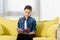 adorable preteen child sitting on yellow sofa and reading book