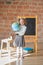 Adorable private schoolgirl in front of blackboard with globe in her hands