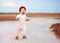 Adorable redhead toddler baby boy in jumpsuit running through the summer road and field