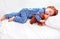 Adorable redhead toddler baby in flannel pajamas sleeping with plush warmer toy