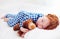 Adorable redhead toddler baby sleeping with plush toy in flannel pajamas