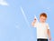 Adorable redheaded boy with paper plane on sky