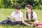 adorable schoolchildren doing homework together while sitting on grass