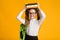 Adorable Schoolgirl Carrying Books On Head, Yellow Background