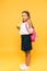 adorable schoolkid holding apple and pointing with finger on orange .