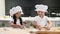 Adorable schoolkids playing with dough and flour in kitchen. Young chefs work together. 4k