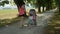 Adorable shot of mom and toddler girl pushing her newborn sister in a stroller.