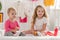 adorable sisters playing with first aid kit in children room and looking