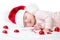 Adorable sleeping newborn baby wearing Santa Claus hat. Christmas, New Year holidays