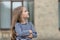 Adorable small kid with long hair wear stripy top casual fashion style keeping arms crossed with confident look outdoors