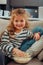 Adorable small long-haired girl with a bright bracelet eating popcorn