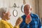 Adorable smiley senior caucasian couple in an old fashioned apartment looking at each other and smiling while holding