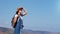 Adorable smiling active female hiker admiring amazing nature standing on top of mountain