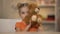 Adorable smiling girl holding brown teddy bear, joyful kid, happy childhood