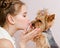 Adorable smiling little girl child schoolgirl holding and playing with pet dog