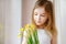 Adorable smiling little girl holding daffodils