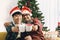 Adorable smiling young LGBT couple sharing special moment together on Christmas holiday, Asian gay male lover sitting on sofa,