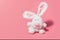 Adorable stuffed bunny on pink background with copy space.