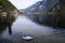 Adorable swan swimming in reflecting lake Hallstatt surrounded by mountains in Austria