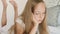 Adorable teenage girl lying on bed and using red mobile phone