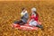 Adorable teens communicate drink tea talk while sitting in a park on a plaid picnic