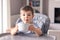 Adorable thankful little baby boy with smeared face just finished his tasty meal and hold white bowl