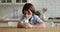 Adorable thirsty little child boy drinking glass of milk.